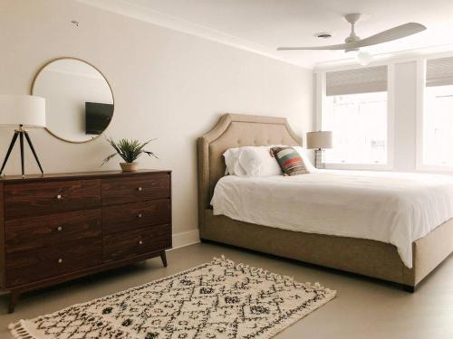 a bedroom with a bed with a mirror and a dresser at Cru Loft in the Heart of Downtown Knox in Knoxville