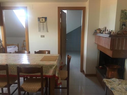 een eetkamer met een tafel en een open haard bij Casa Fara Gino in Ascoli Piceno