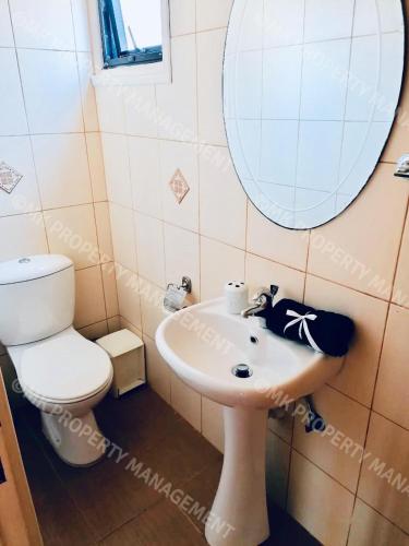 a bathroom with a toilet and a sink and a mirror at Merika Complex 1 Hou.32 in Larnaca