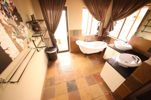 a bathroom with two sinks and a tub and a toilet at Makhato Bush Lodge 109 in Bela-Bela