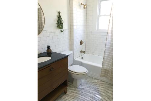ein Badezimmer mit einem WC, einem Waschbecken und einer Badewanne in der Unterkunft 1940's Bungalow near Downtown & UT Campus in Knoxville