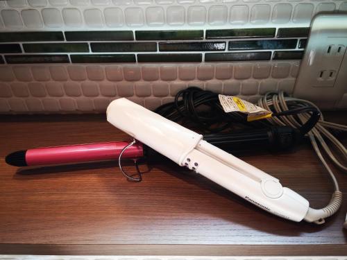 a wii remote laying on the floor next to a phone at Guesthouse Kobe Nadeshikoya in Kobe