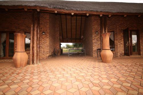 a brick building with vases in the middle of a patio at Makhato Bush Lodge 109 in Bela-Bela