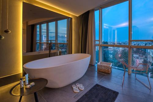 ein Badezimmer mit einer großen Badewanne und einem großen Fenster in der Unterkunft Arkk Homes in Antalya