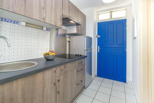 uma cozinha com uma porta azul e um lavatório em Boucan Beach Joli studio vue mer à Boucan Canot em Boucan Canot