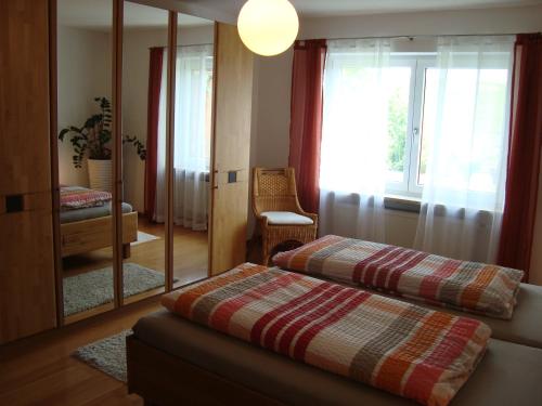 sypialnia z 2 łóżkami i lustrem w obiekcie Ferienwohnungen Krenn w mieście Tittling