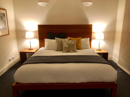 a bedroom with a large bed with two lamps at Lochiel Luxury Accommodation in Olinda
