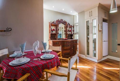 a dining room with a table with a red table cloth at Craigivar Guesthouse in Pretoria