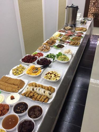 een buffet met veel verschillende soorten eten bij Erkin Palace Hotel in Khiva