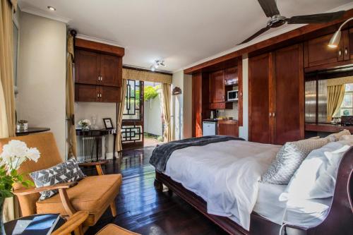 a bedroom with a bed and a couch and a chair at Craigivar Guesthouse in Pretoria
