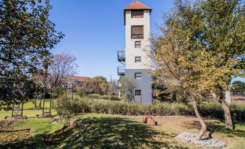 a building with a clock tower in a park at Craigivar Guesthouse in Pretoria