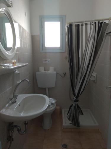 a bathroom with a sink and a toilet and a window at Villa Dioni in Kamari