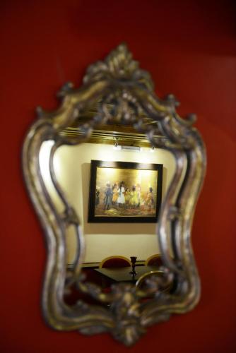 a mirror with a picture of a group of people at Archontiko Deligianni in Dhimitsana
