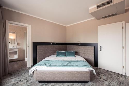 a bedroom with a large bed with blue pillows at Felderer Boutiquehotel in Caldaro
