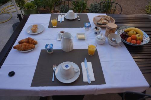 - une table blanche avec de la nourriture pour le petit-déjeuner dans l'établissement midi03, à Carcassonne