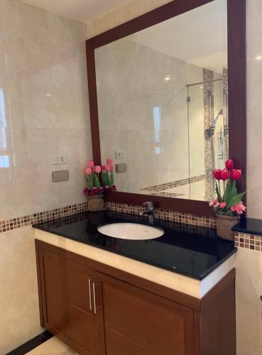 a bathroom with a sink and a large mirror at Jomtien Beach Penthouses Condo in Jomtien Beach