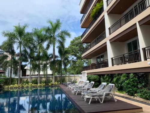 a hotel with a swimming pool and lounge chairs at Jomtien Beach Penthouses Condo in Jomtien Beach
