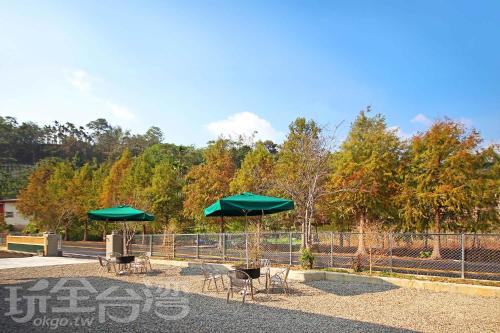 two green umbrellas and some tables and chairs at XiangLin Homestay in Yuchi