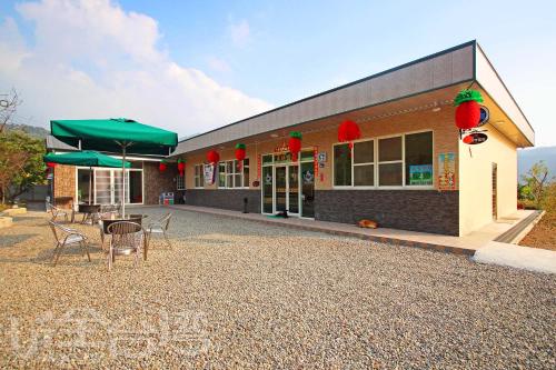 a building with chairs and umbrellas in front of it at XiangLin Homestay in Yuchi