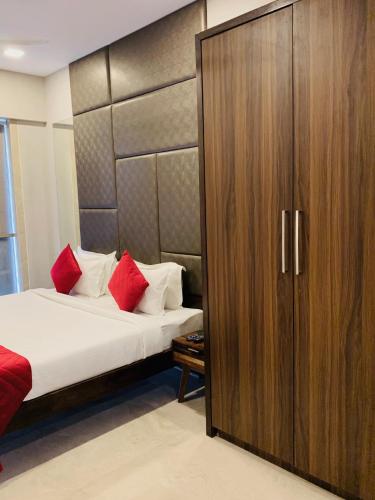 a bedroom with a bed and a large wooden cabinet at Theory9 Premium Service Apartments Khar in Mumbai