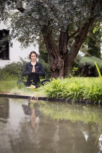 a woman sitting next to a body of water at Felderer Boutiquehotel in Caldaro