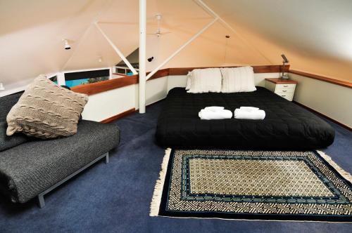 una camera con due letti e un divano in esso di Beach Views Holiday Home a Nelson