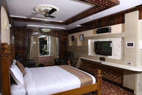 a bedroom with a bed and a flat screen tv at Beverly villa in Ooty