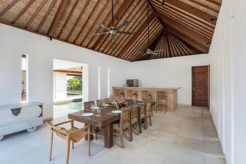 comedor con mesa de madera y sillas en Beraban Beach House en Tabanan