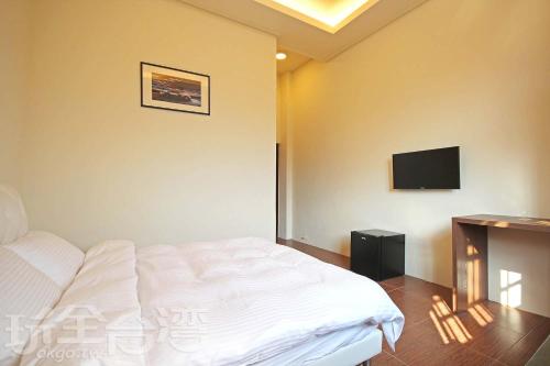 a bedroom with a bed and a tv on the wall at XiangLin Homestay in Yuchi