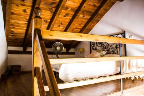 Litera en habitación con techo de madera en El Andarrio, en Buitrago del Lozoya