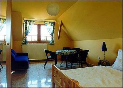 a bedroom with a bed and a table and chairs at Palatinus Apartmanok in Keszthely