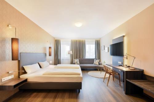 Pokój hotelowy z łóżkiem i biurkiem w obiekcie Hotel Säntis w Monachium