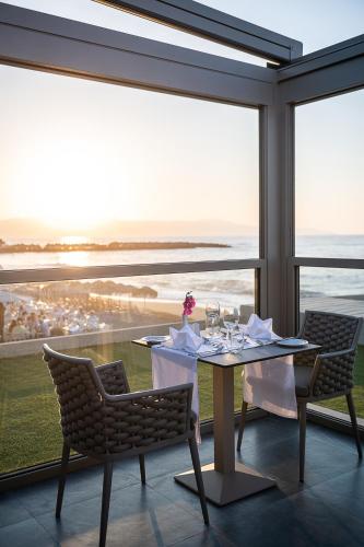 a dining room with a table with a view of the ocean at Porto Platanias Beach Luxury Selection - Adults Only in Plataniás