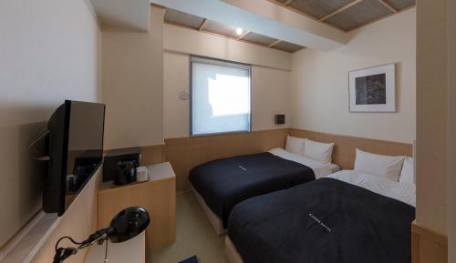 Postel nebo postele na pokoji v ubytování Kamon Hotel Namba