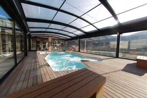 een zwembad met een glazen dak op een terras bij Aparthotel SPA Don Iñigo de Aragón in Las Cuevas de Cañart