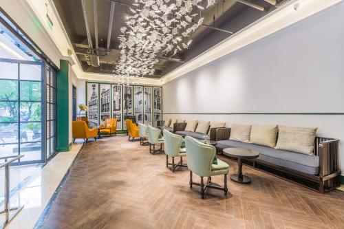 a waiting room with a couch and chairs at Hangzhou Lanshe hotel in Hangzhou