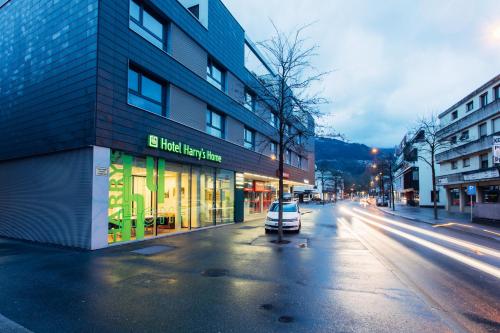 un'auto parcheggiata di fronte a un edificio in una strada di harry's home Dornbirn hotel & apartments a Dornbirn