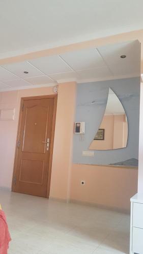 Cette chambre comprend une porte et un miroir. dans l'établissement Apartamento, en pueblo pesquero, à Les Cases d'Alcanar