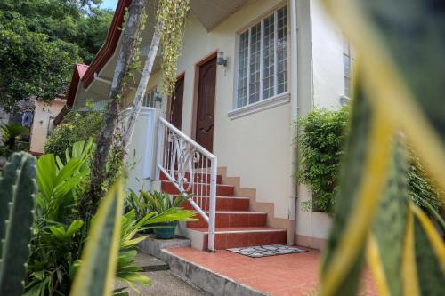 a house with a staircase leading to a door at RQS Hostel in Tacloban