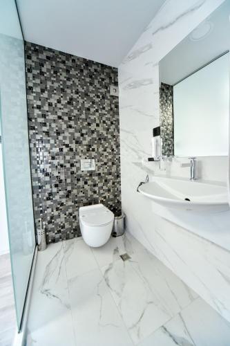 a bathroom with a sink and a toilet and a mirror at Стаи за гости Десита in Blagoevgrad