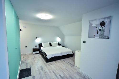 a bedroom with a bed and a painting on the wall at Стаи за гости Десита in Blagoevgrad