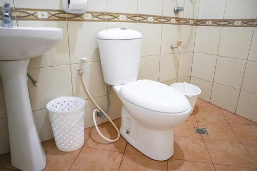 a bathroom with a toilet and a sink at RQS Hostel in Tacloban