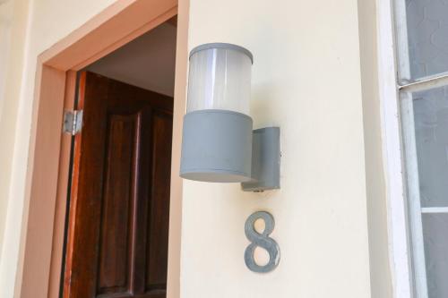 a light on the side of a house with a number eight at RQS Hostel in Tacloban