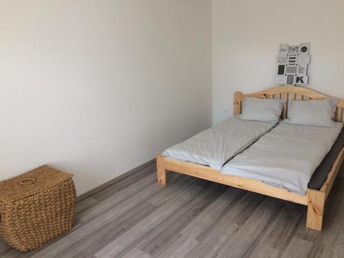 a bed with a wooden frame in a room at Little Greece in Balatonfüred