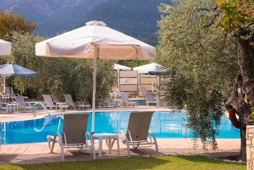 a swimming pool with chairs and an umbrella next to a pool at Ocean Beach Hotel in Skala Potamias