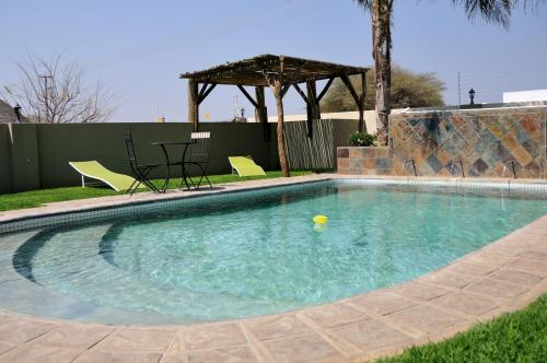 a swimming pool with a yellow ball in the water at Hadassa Guest House in Otjiwarongo