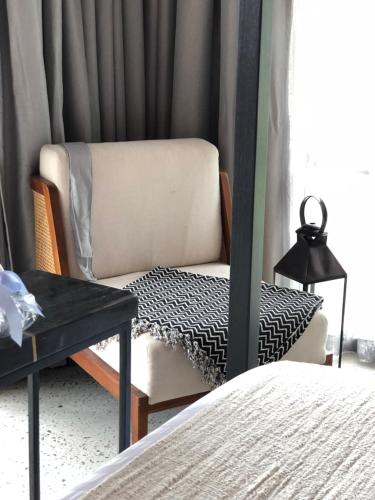a bedroom with a chair and a bed at Laman Villa Port Dickson in Port Dickson