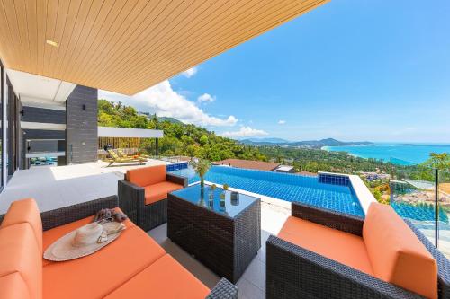 an outdoor patio with orange furniture and a swimming pool at Samui Villa Bebe in Bophut 
