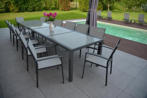 a table and chairs with a vase of flowers on a patio at la maison du saussoy in Saint-Augustin