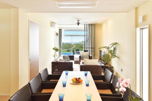 a dining room with a table and chairs at Feliz Villa Suite Irabujima Sawada in Miyako-jima